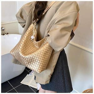Detailansicht einer goldenen Flecht-Handtasche mit modischem Logo und Textur-Finish