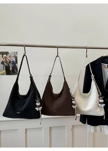 Detailed display of large capacity tote bags in black, dark brown and beige with charms