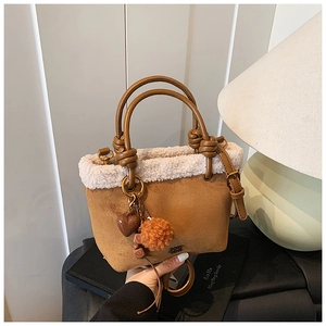 Dettaglio borsa a secchiello in pelle scamosciata marrone con bordo in shearling