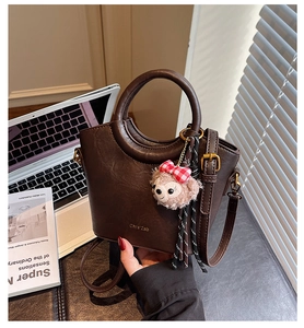 Sac Boston en similicuir marron avec breloque ours rose et détails du logo doré