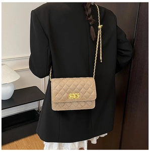 Detail of beige quilted crossbody bag featuring gold chain strap and metal lock closure
