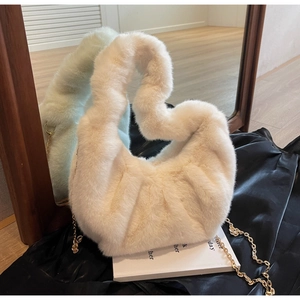 Detail view of cream faux fur handbag with soft texture and elegant gold metal chain