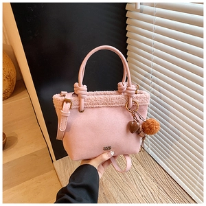 Dettaglio borsa a secchiello rosa scamosciata con bordo in peluche e ciondolo a cuore