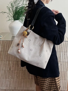 Sac cabas rétro beige en daim avec motifs floraux ajourés et breloque à pompon
