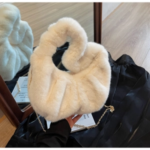 Close-up of cream faux fur handbag with knotted handle and fine gold chain strap