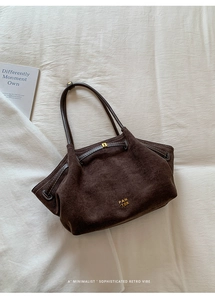Detailed close-up of dark brown vintage suede tote bag with PAN 'TOR logo on white fabric