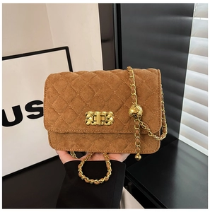 Detail of brown quilted suede crossbody bag with gold chain strap and metal lock