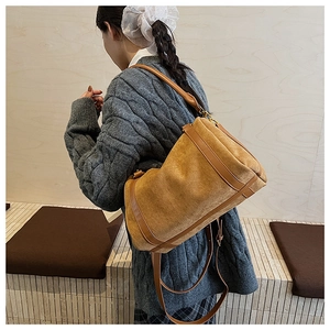 Vue latérale d'un sac Boston vintage en suédine marron avec bandoulière réglable