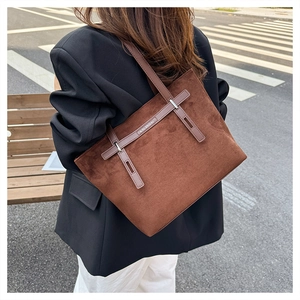 Dettaglio della borsa tote in pelle scamosciata marrone con tracolla in pelle
