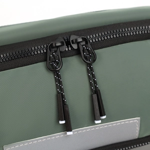 Close-up of waterproof dark green bag with black two-way zippers and reflective stripe