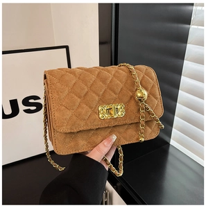 Detail of brown suede quilted crossbody bag with gold chain strap and rotary lock
