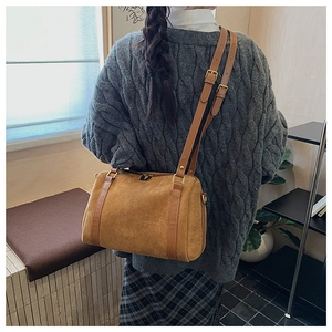 Vue détaillée du sac Boston en daim souple avec bretelles en cuir réglables de couleur camel
