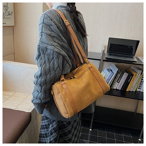Vue détaillée d'un sac Boston vintage en suédine marron avec bandoulière en cuir souple