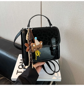 Detail of leopard print flap and teddy bear charm on black vintage backpack for women