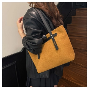 Dettaglio della borsa tote in pelle scamosciata zenzero con cinturini in pelle nera