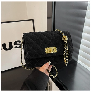 Detailed view of black quilted velvet crossbody bag with golden chain and ball adjustment