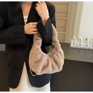 Detail of light brown faux fur crossbody bag with gold chain strap and pleated design