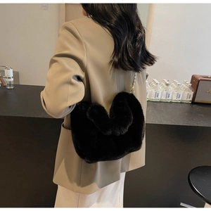 Detail view of heart-shaped faux fur crossbody bag with elegant gold chain strap
