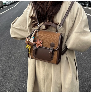 Detailed view of vintage leopard print backpack with brown leather stitching and charms