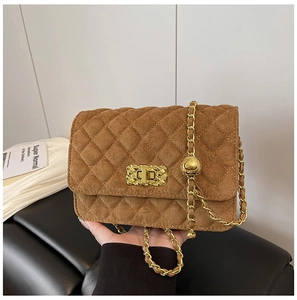 Close-up of caramel brown quilted suede crossbody bag with gold chain and twist lock detail