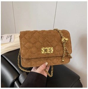 Detailed shot of brown quilted suede bag with gold twist lock and chain strap