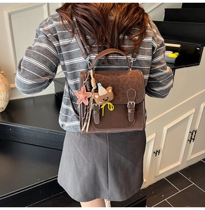 Detail showing vintage leopard print backpack with brown leather flap and cute charms