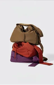 Detailed stack of nylon tote bags in brown, orange and purple with drawstring texture