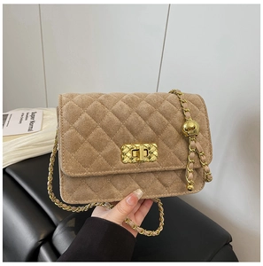 Detail of tan quilted velvet crossbody bag with golden turn-lock and chain strap