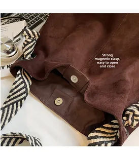 Close-up of brown suede tote bag featuring strong magnetic buckles and woven strap