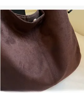 Macro shot of dark chocolate suede tote bag showing soft texture and stitching detail