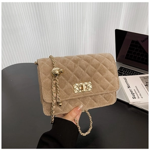 Close-up of khaki velvet quilted texture and gold turn-lock on the chain bag
