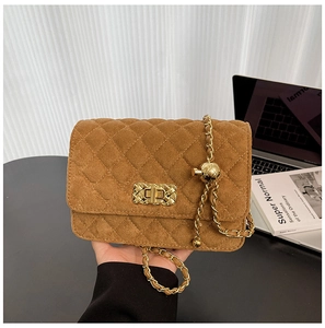 Detail view of brown quilted suede shoulder bag with gold chain and adjustable buckle