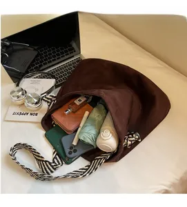 Spacious interior of a brown suede tote bag showing storage for umbrella, phone and water bottle