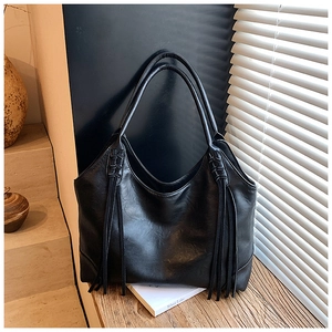 Détail d'un grand sac cabas Hobo noir en cuir avec de longues franges décoratives