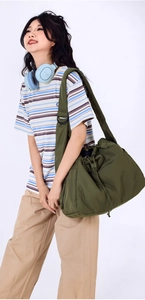 Olive green quilted nylon tote bag with drawstring closure and wide adjustable shoulder strap