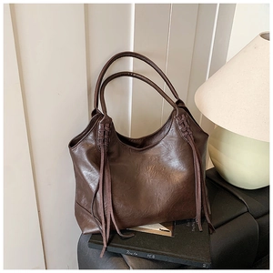Détails du sac cabas marron foncé avec bandoulière tressée et longs pompons décoratifs