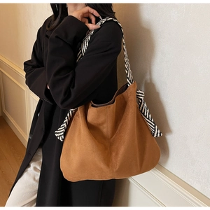 Brown faux suede hobo tote bag with striped woven strap and side bow details