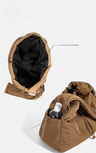 Detail view of large brown quilted tote bag with side pocket for water bottle storage