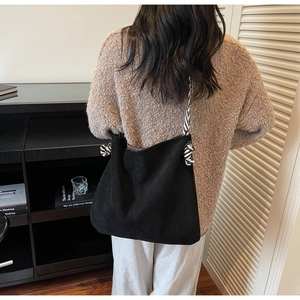 Close-up of black suede tote bag with zebra print rope strap and knot detail