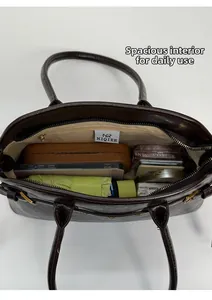 Vue de dessus de l'intérieur du grand sac cabas marron avec accessoires quotidiens