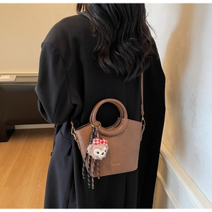Sac seau marron en similicuir avec charm en peluche rose et bandoulière réglable