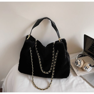 Détail du sac bandoulière en fausse fourrure noire avec chaîne dorée et lanière
