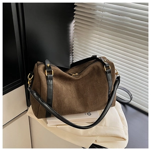 Détail du sac Boston en daim café avec ferrures dorées et accents de bandoulière noire