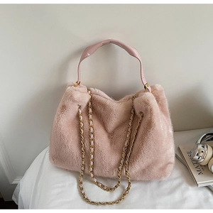 Détail du sac cabas en fausse fourrure rose avec chaînes dorées et cuir souple