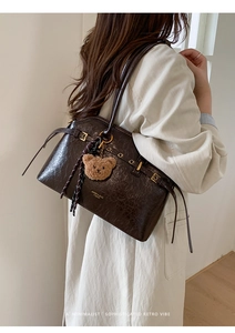 Vue détaillée du grand sac cabas rétro marron foncé avec de longues franges et métal doré