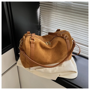 Détail du sac Boston en daim caramel avec lanières en cuir et fermetures dorées