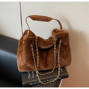 Détail du sac à main en fausse fourrure marron avec anse en cuir et bandoulière en chaîne