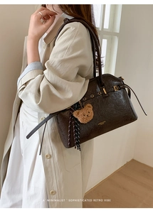 Détail du sac cabas vintage marron foncé avec boucle dorée et pendentif ourson