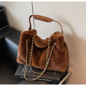 Détail du sac à main en fausse fourrure marron avec chaîne dorée sur siège en cuir