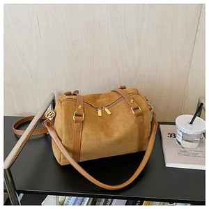 Détail du sac boston en daim caramel montrant les doubles fermetures éclair et la bandoulière